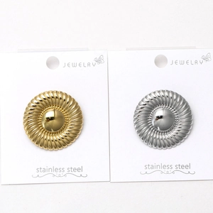 Detail view of gold and silver stainless steel brooches with spiral textured finish