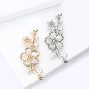 Elegante spilla a fiore di pesco con perle e strass su piattaforme geometriche