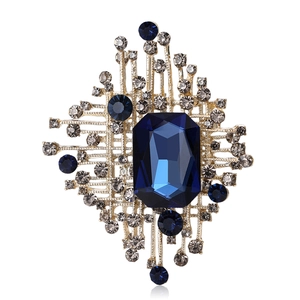 Spilla dorata elegante con cristallo blu taglio smeraldo e accenti di zaffiro