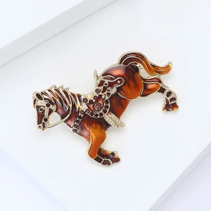 Detailed close-up of a jumping horse brooch with amber enamel and gold finish details