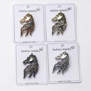 Detail view of vintage horse head brooches in four metal finishes with rhinestones
