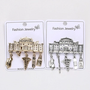 Detailed close-up of hospital-themed metal pins with medical pendants on display cards