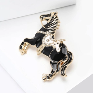 Close-up of black enamel horse brooch with sparkling rhinestones on golden alloy base