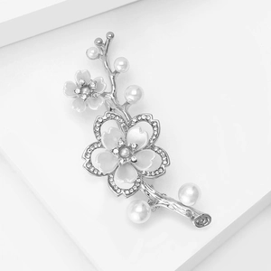 Dettaglio di una spilla a bouquet d'argento con perle bianche e strass scintillanti