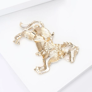 Detail view of the gold horse brooch back featuring cast texture and secure safety pin