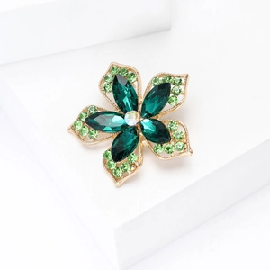 Détail macro de la broche fleur à cinq pétales avec strass et cristaux vert émeraude