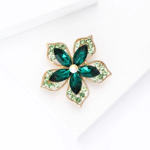 Détail macro de pétales de cristal vert et broche fleur creuse dorée de qualité