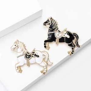 Detailed view of horse brooches with enamel finish and shimmering crystal accents