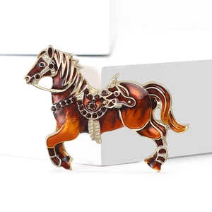 Exquisite gold-plated horse brooch with amber enamel and rhinestones on a white stand