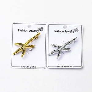 Détail de broches en forme de griffes en or et argent avec cartes de bijoux fantaisie