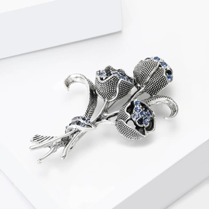 Dettaglio della spilla a tulipano vintage con strass blu su supporto da esposizione