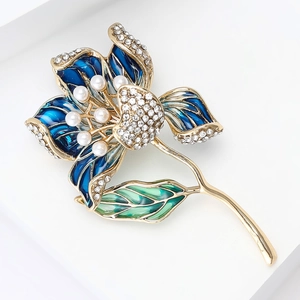Vue détaillée de la broche florale dorée avec émail bleu et perles fantaisie nacrées