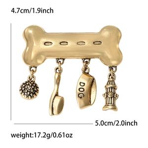Vintage gold-toned bone brooch featuring pet-themed charms like a comb, bowl, and hydrant