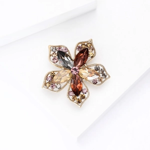 Vue macro d'une broche fleur dorée avec strass marquise et détails de pétales complexes