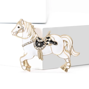 Exquisite carousel horse brooch in gold alloy with white enamel and sparkling rhinestones