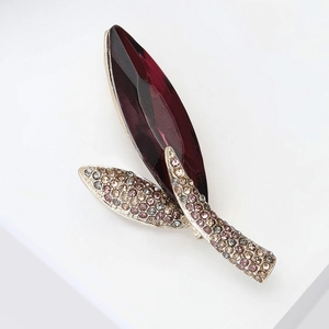 Detailed macro view of an elegant marquise-cut deep red crystal leaf brooch decoration
