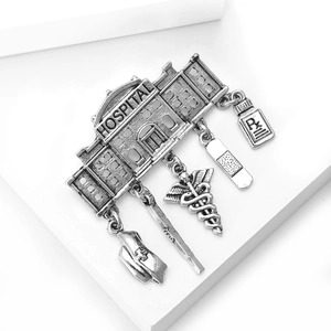 Macro view of vintage medical charms including a hospital building and Rx bottle