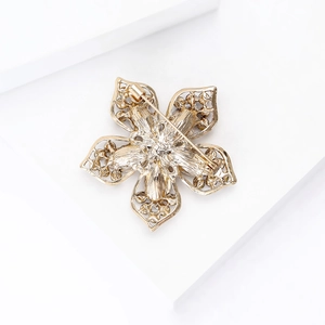 Vue détaillée du dos d'une broche fleur dorée montrant le design évidé et le fermoir à épingle