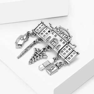 Detailed close-up of retro silver medical brooch with hospital pendants and charms