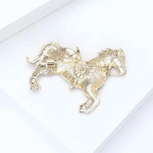 Detailed back view of the golden horse brooch showing the pin mechanism and metal texture