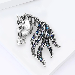 Close-up of vintage silver horse head brooch with blue and purple crystal rhinestones