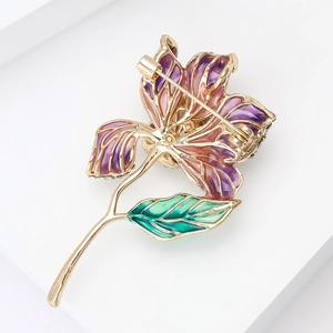 Détail d'une broche hibiscus en émail violet avec base dorée et cristaux brillants