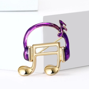 Elegant gold music note brooch with purple headphones and fine enamel craftsmanship