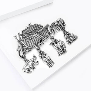 Detailed close-up of retro silver Noah's Ark brooch with hanging animal charms on steps