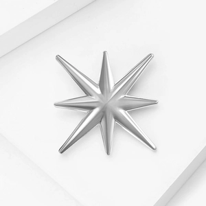 Gros plan d'une broche étoile octogonale argentée avec une finition miroir lisse
