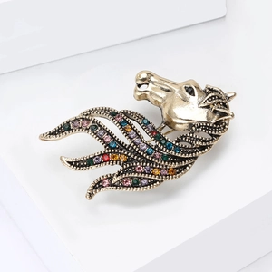 Detailed close-up of retro golden horse head brooch with multi-colored crystals on white block