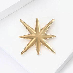 Détail d'une broche étoile dorée minimaliste avec une finition métallique mate