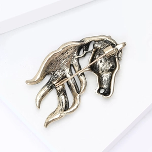 Detailed back view of vintage bronze horse head brooch showing secure safety pin