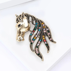 Detailed close-up of retro golden horse head brooch with sparkling colorful rhinestones