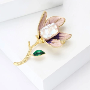 Elegant magnolia brooch with baroque pearl and pink enamel petals on white background