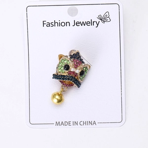 Detailed macro view of a vintage Chinese lion head brooch with colorful rhinestones