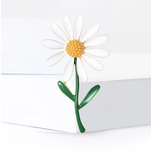 Broche fleur de marguerite blanche avec cœur jaune et feuilles vertes sur fond blanc