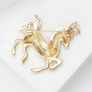 Detailed view of the gold horse brooch back featuring a secure safety pin fastener