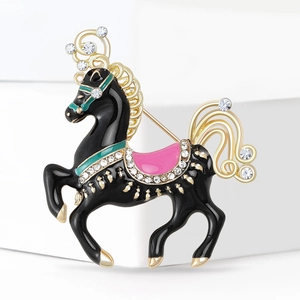 Close-up of elegant horse brooch with black enamel, sparkling rhinestones, and gold trim