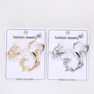 Close-up of gold and silver hollow squirrel brooches on fashion jewelry card display