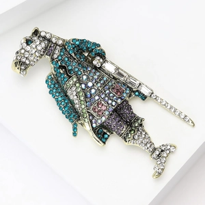 Macro detail of vintage horse shield brooch featuring colorful crystals and golden finish