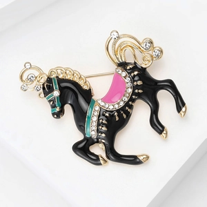 Detailed close-up of a carousel horse brooch with black enamel and sparkling rhinestones