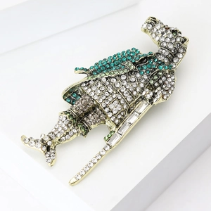 Macro shot of vintage horse knight brooch with emerald zircons on white platform