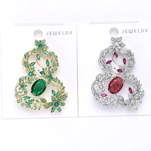 Détail de broches calebasse ajourées avec zircons de couleur sur cartes blanches