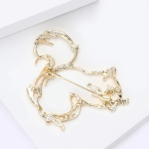 Elegant gold hollow squirrel brooch with hammer texture on a white geometric background