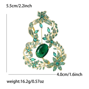 Vue détaillée montrant les dimensions d'une broche calebasse évidée en or et cristaux verts