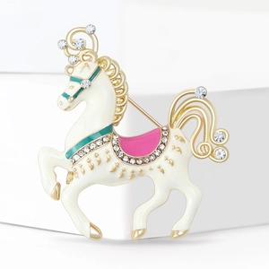 Detailed view of carousel horse brooch with white enamel, gold plating and crystals