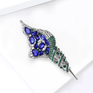 Vue détaillée d'une broche conque de luxe avec pierre bleue et cristaux multicolores