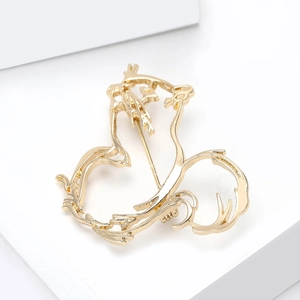 Macro detail of gold-plated alloy squirrel brooch with smooth hollowed-out surface
