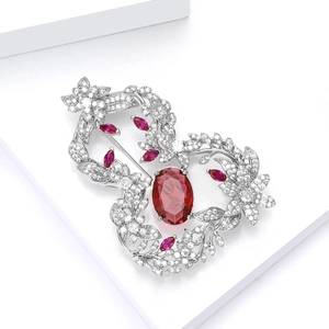 Macro detail of luxury floral brooch with red ruby stones and white zircon stones