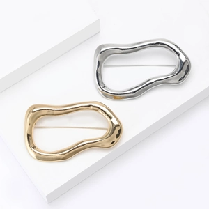 Minimalist irregular wavy hollow brooch in polished gold and silver metallic finishes